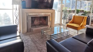 A modern living room with a fireplace, a flat-screen TV, and comfortable seating. - Suites Cusco (Cusco)