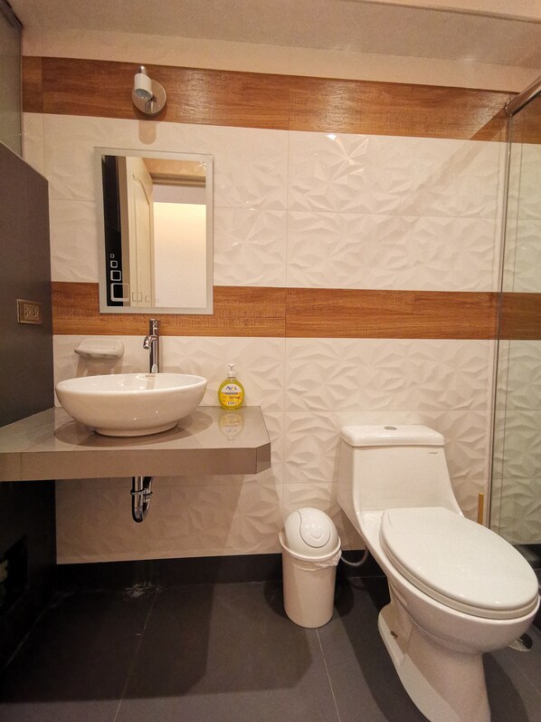 A modern bathroom with a white sink, a mirror, and a toilet. - Suites Cusco (Cusco)