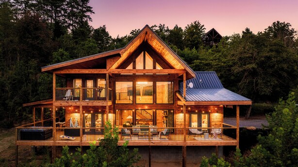 A large wooden cabin with multiple levels, large windows, and a balcony. - Chara Vista Cabin: A Smoky Mountain Retreat (Sevierville)