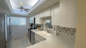 Eine moderne Küche mit Oberlicht, Kühlschrank, Herd und Spüle.