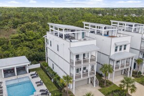 Ein modernes Mehrstöckhotel mit Balkonen, einem Pool und üppiger Bepflanzung rund um das Anwesen.