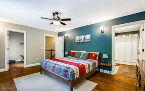 A bedroom with a bed, a ceiling fan, and a nightstand with a lamp. - Mountain Dreams (Massanutten)