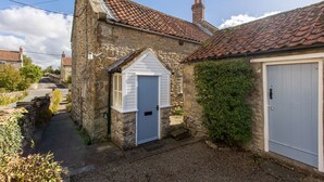 A stone building with a small white door and a garage door.