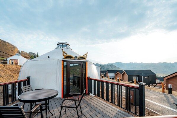 A yurt with a wooden deck, a table, and chairs. - Blue Spot Resort (Ulaanbaatar)