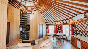 A modern interior with a wooden ceiling, a sofa, a dining area, and a kitchen. - Blue Spot Resort (Ulaanbaatar)