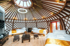 A traditional yurt with two beds, a wooden floor, and a central seating area. - Blue Spot Resort (Ulaanbaatar)
