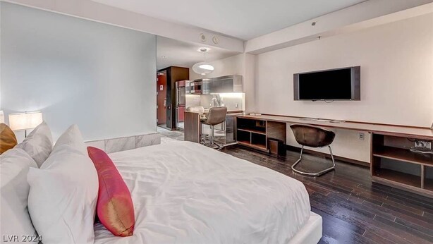 A modern hotel room with a large bed, a desk, a chair, a television, and a kitchenette in the background. - PALMS  (Las Vegas)