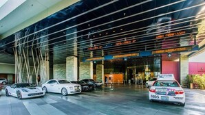 A modern hotel entrance with a glass facade, valet check-in, and a taxi stand. - PALMS  (Las Vegas)
