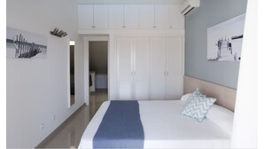 Una camera da letto con un letto, un armadio e un quadro appeso al muro.