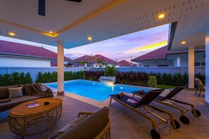 Una piscina al aire libre, tumbonas