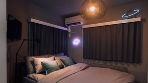 A modern bedroom with a bed, a standing lamp, an air conditioning unit, and a ceiling light fixture. - Showa Bloom · Cozy Stay Near Shinjuku (Tokyo)