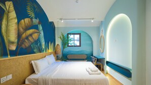 Camera da letto con un letto grande, un tavolino, una panca e un affresco al muro.