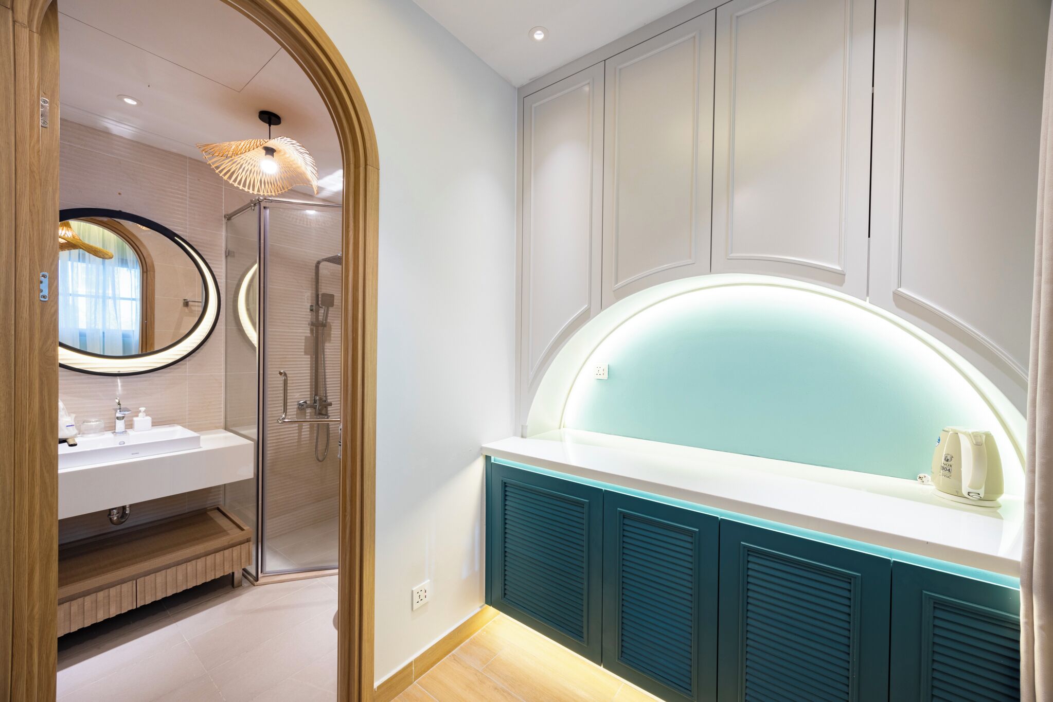 A modern bathroom with a glass shower, a vanity with a mirror, and a unique light fixture.