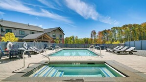 A rectangular pool with a tiled deck, lounge chairs, and a wooden deck area. - Ski-In Out on Okemo, 25 minutes to Killington, 8 minutes to Fox Run Golf Club! (Ludlow)