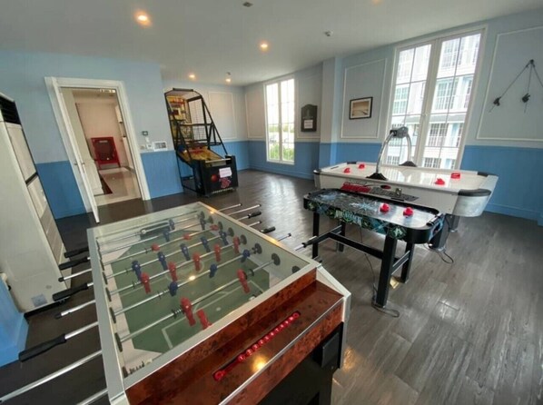 A room with two foosball tables, a pool table, and a staircase leading to another area. - GrandFlorida 1Bedroom CloseToBeach D716 (Sattahip)