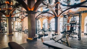 Ein großzügiger Fitnessraum mit verschiedenen Trainingsgeräten, darunter Kraftgeräte und Cardiogeräte.