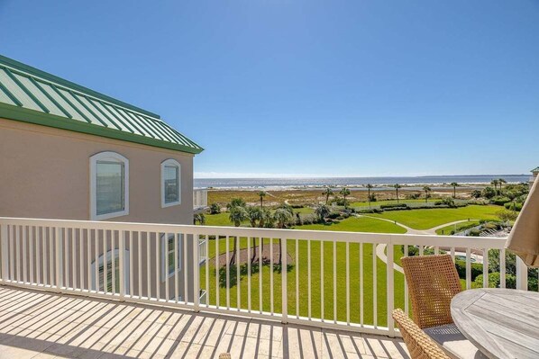 A balcony with a view of a golf course and ocean. - Luxurious Oceanfront Condo. Enjoy the Perfect Trip (Saint Simons Island)