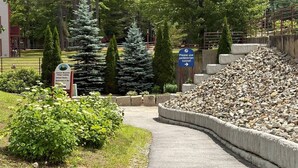 A pathway leading to a building with a sign indicating a pedestrian tunnel. - Attitash Room: Pool, Hot Tub, Storyland, Foliage (Bartlett)
