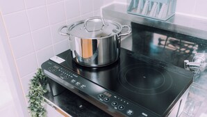 Un piano cottura a induzione moderno con una pentola in acciaio inossidabile sopra.