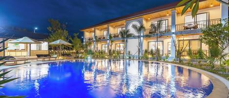 Vista frontal de la propiedad por la tarde o noche