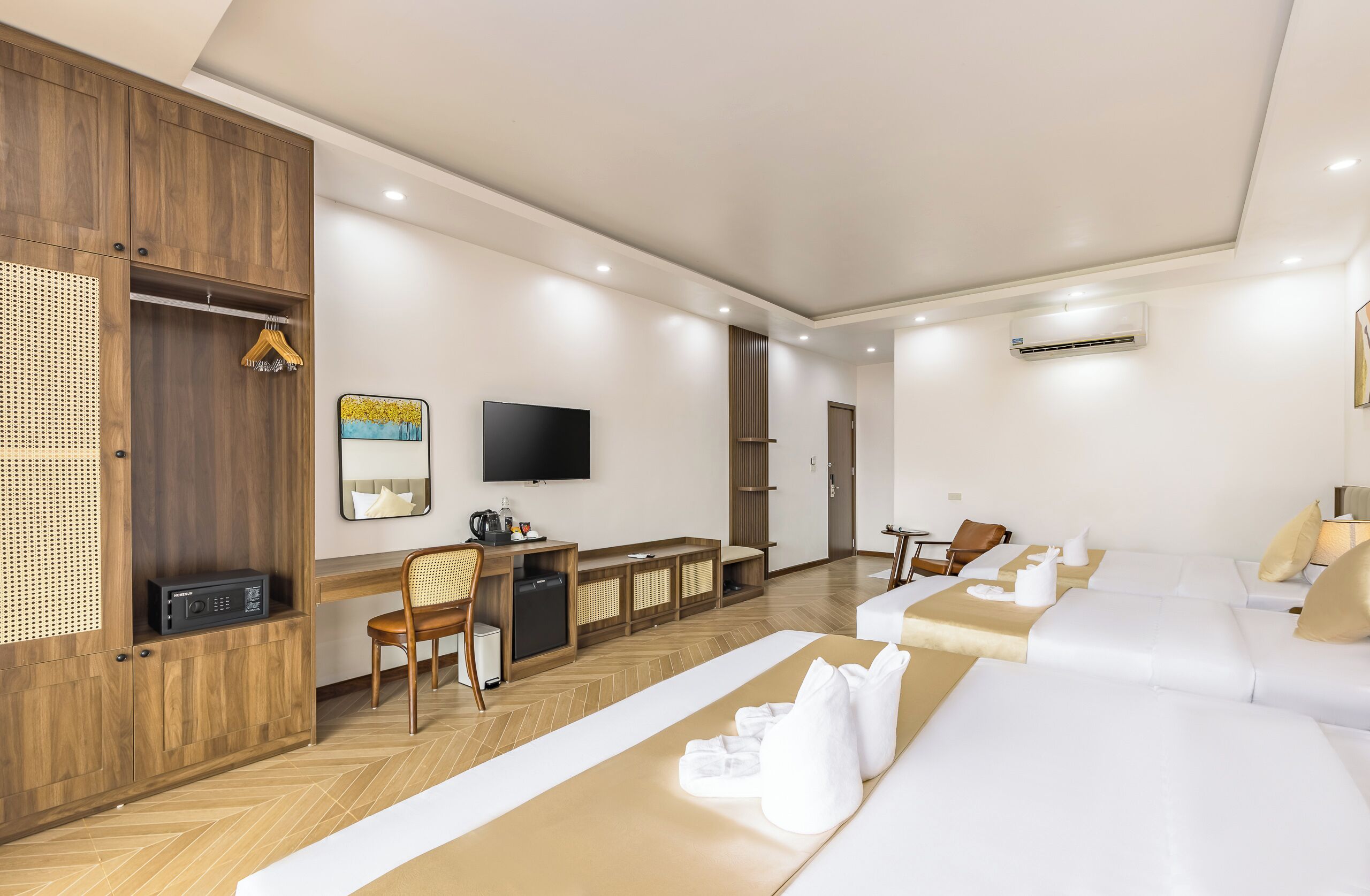 Una habitación de hotel moderna con un armario de madera, un escritorio con silla, un televisor de pantalla plana, un sofá y una cama.