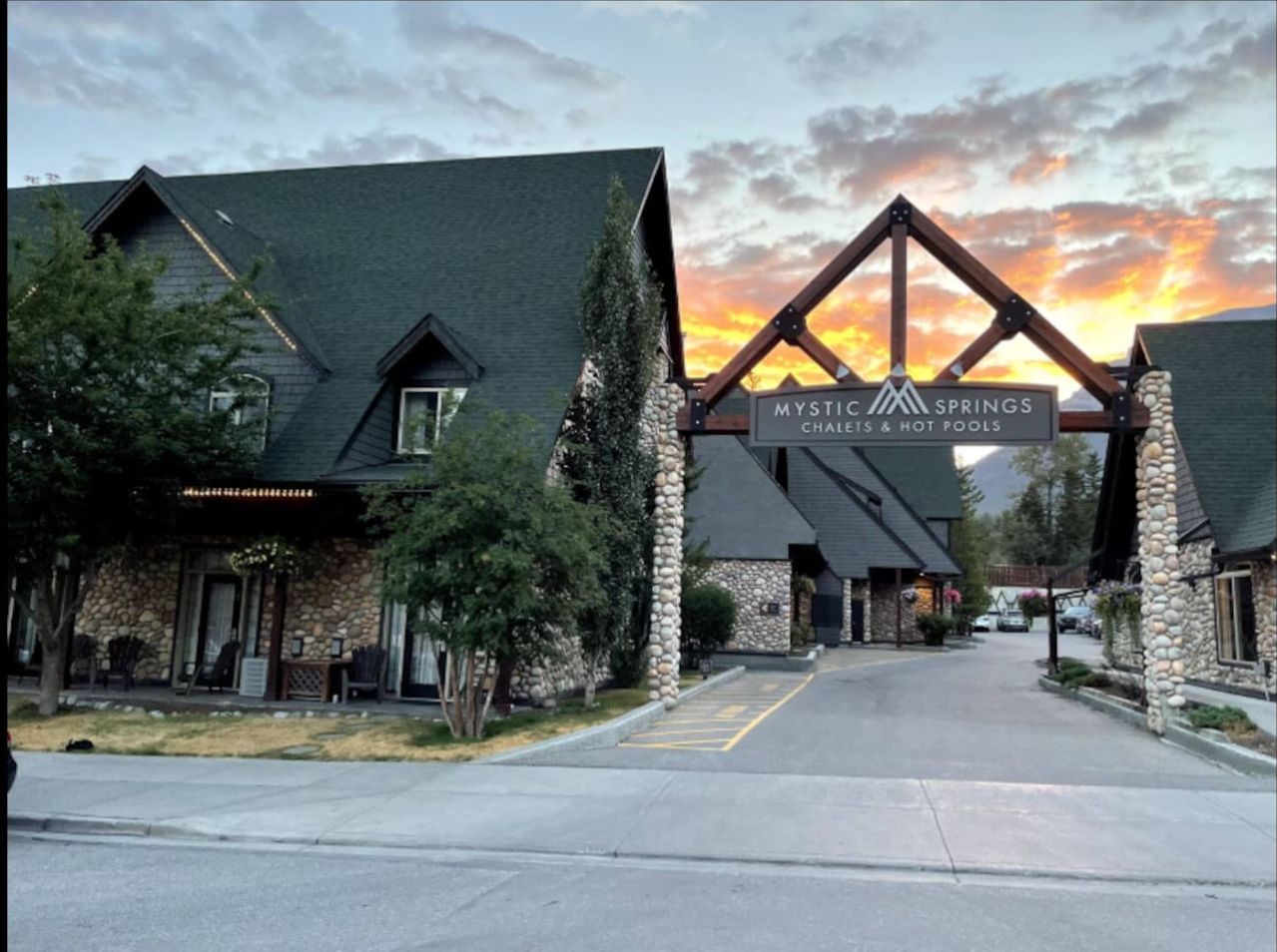 Ein Gebäude mit einer Steinfassade und einem großen Schild mit der Aufschrift 'Mystic Springs Chalet & Hot Pools'.