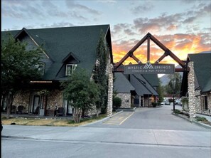 Ein Gebäude mit einer Steinfassade und einem großen Schild mit der Aufschrift 'Mystic Springs Chalet & Hot Pools'.