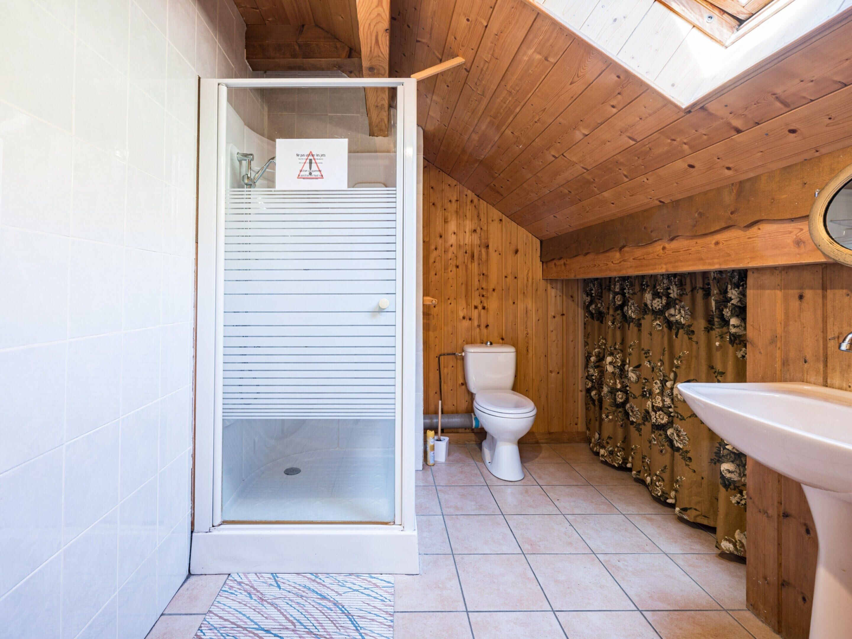 A bathroom with a shower, toilet, and sink.