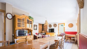 A spacious kitchen with wooden cabinets, a dining table, and chairs.
