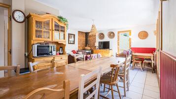 A spacious kitchen with wooden cabinets, a dining table, and chairs.