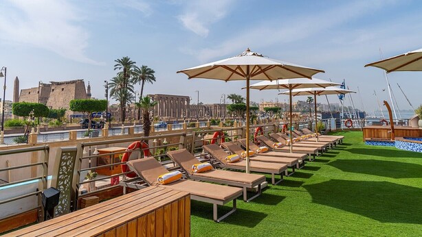 A rooftop lounge area with sun loungers, umbrellas, and a view of the cityscape. - Sonesta Sun Goddess Nile cruise ship - 4 & 7 nights - From Luxor every Monday (Luxor)