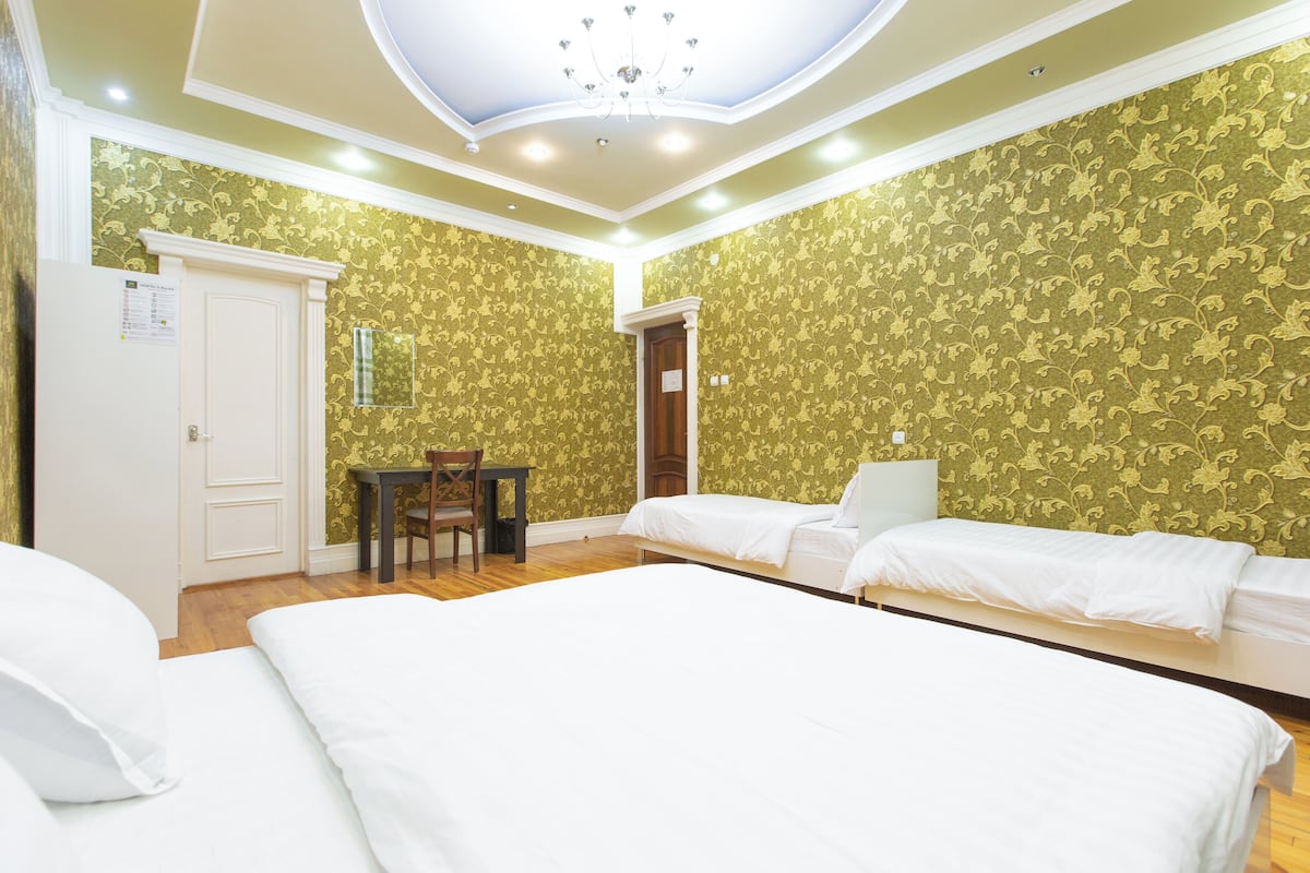 A hotel room with two beds, a desk, and a chair.