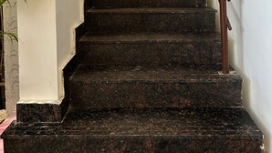 A staircase with a handrail and a yellow curtain at the top. - Hotel SM Stay INN (Bengaluru)