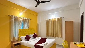 A hotel room with a bed, a desk, and a chair. - Hotel SM Stay INN (Bengaluru)