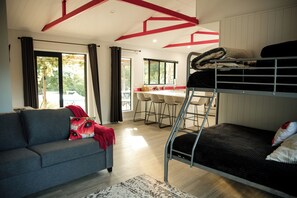 Un intérieur moderne avec un lit superposé, un canapé et un coin repas.