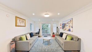 A living room with two sofas, a coffee table, and a large window with a view.