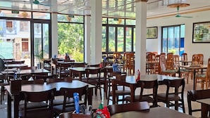 A spacious restaurant with high ceilings, large windows, and wooden tables and chairs. - VISTA TAM COC HOTEL (Nam Hoa Lu)