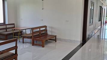 A clean, modern interior with a bench, table, and a wall-mounted fan.