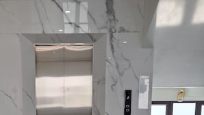 A modern elevator with a marble wall and a digital display. - VISTA TAM COC HOTEL (Nam Hoa Lu)