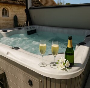 A hot tub with two glasses of champagne and a bottle, surrounded by white flowers. - 10 min from Beaune, near Dijon, hot tub available year-round, absolute tranquility (Corgengoux)