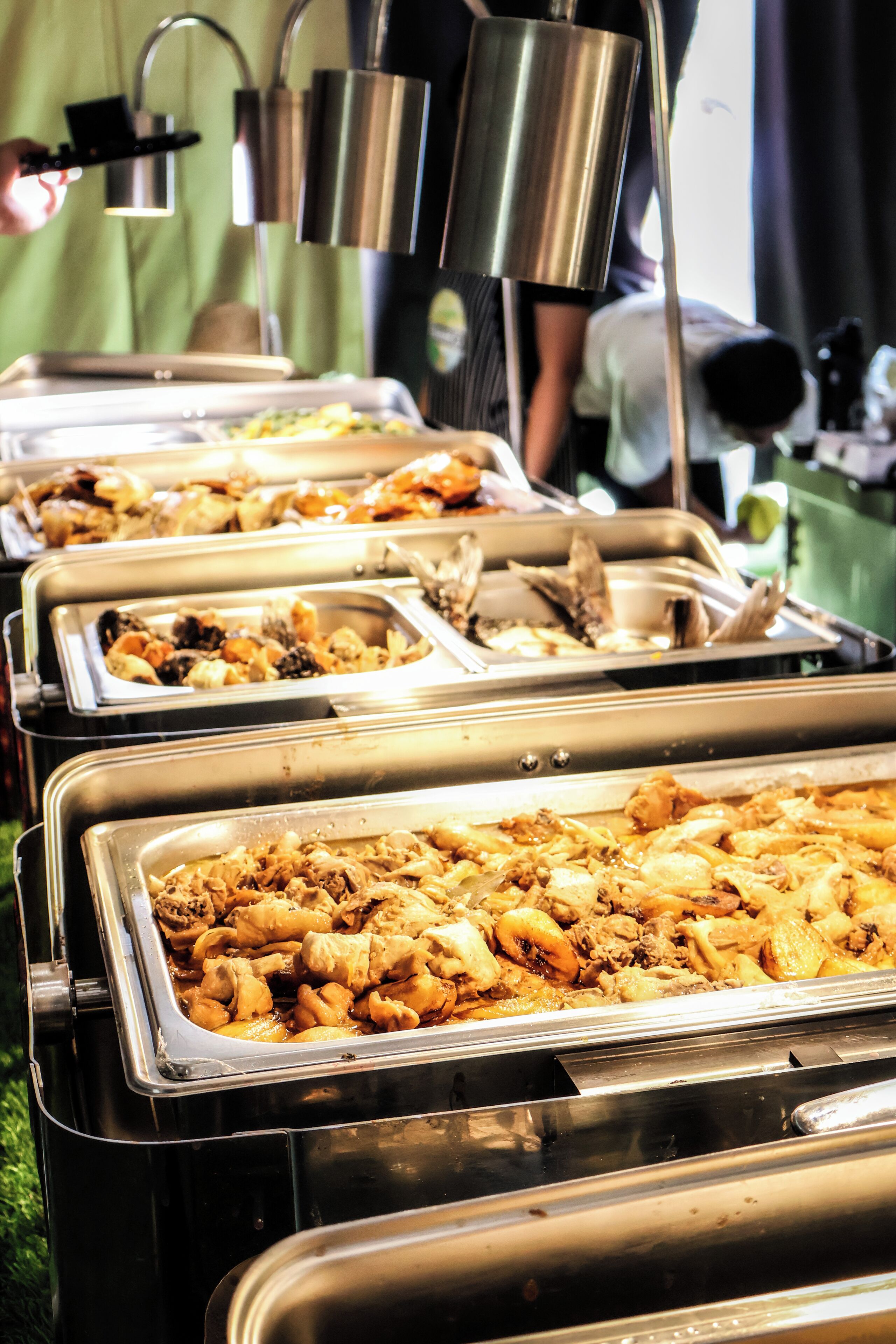 Un bufé con diferentes alimentos presentados en fuentes de metal.