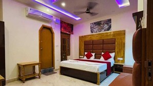 A modern bedroom with a bed, a bedside table, a wooden bench, and a ceiling fan.