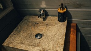 A stone sink with a faucet and a soap dispenser. - L'annexe (Sonnay)