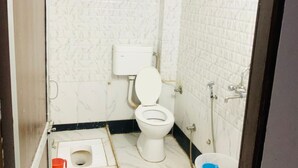 A small, compact bathroom with a toilet, a shower, and a sink. - Hotel Churu Palace (Jaipur)