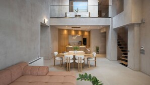 Un intérieur moderne comprenant un espace repas, une cuisine et un escalier.