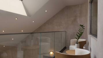 A modern interior with a skylight, glass railing, and contemporary seating.