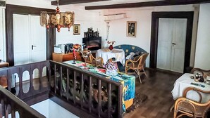 Un comedor con una mesa, sillas, una araña, un televisor y una chimenea.