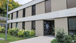 A modern building with a flat facade, large windows, and a numbered entrance.
