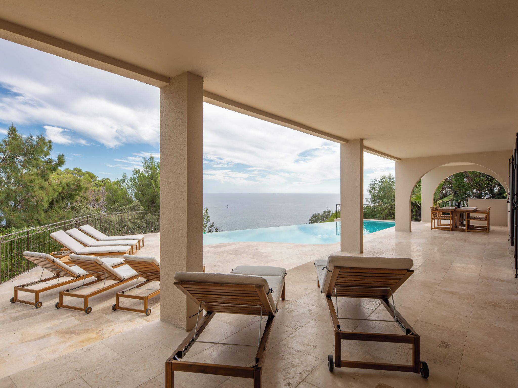 Area esterna coperta con poltrone relax e piscina, con vista sul mare.