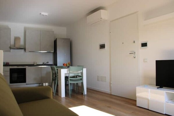 A compact living space with a kitchenette, a dining area, and a seating area.